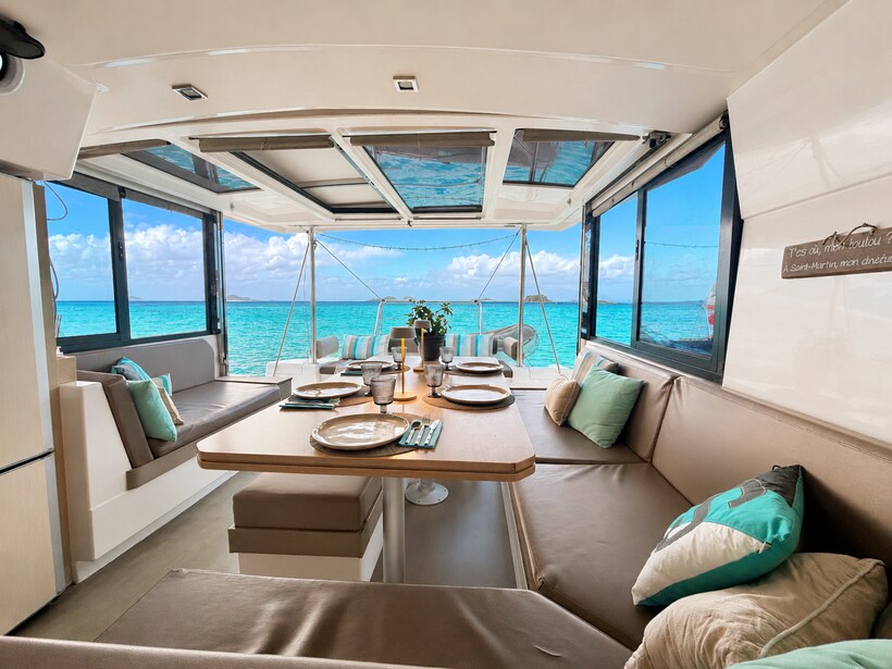 Zephyr's saloon laid for lunch, bay doors open on the anchorage