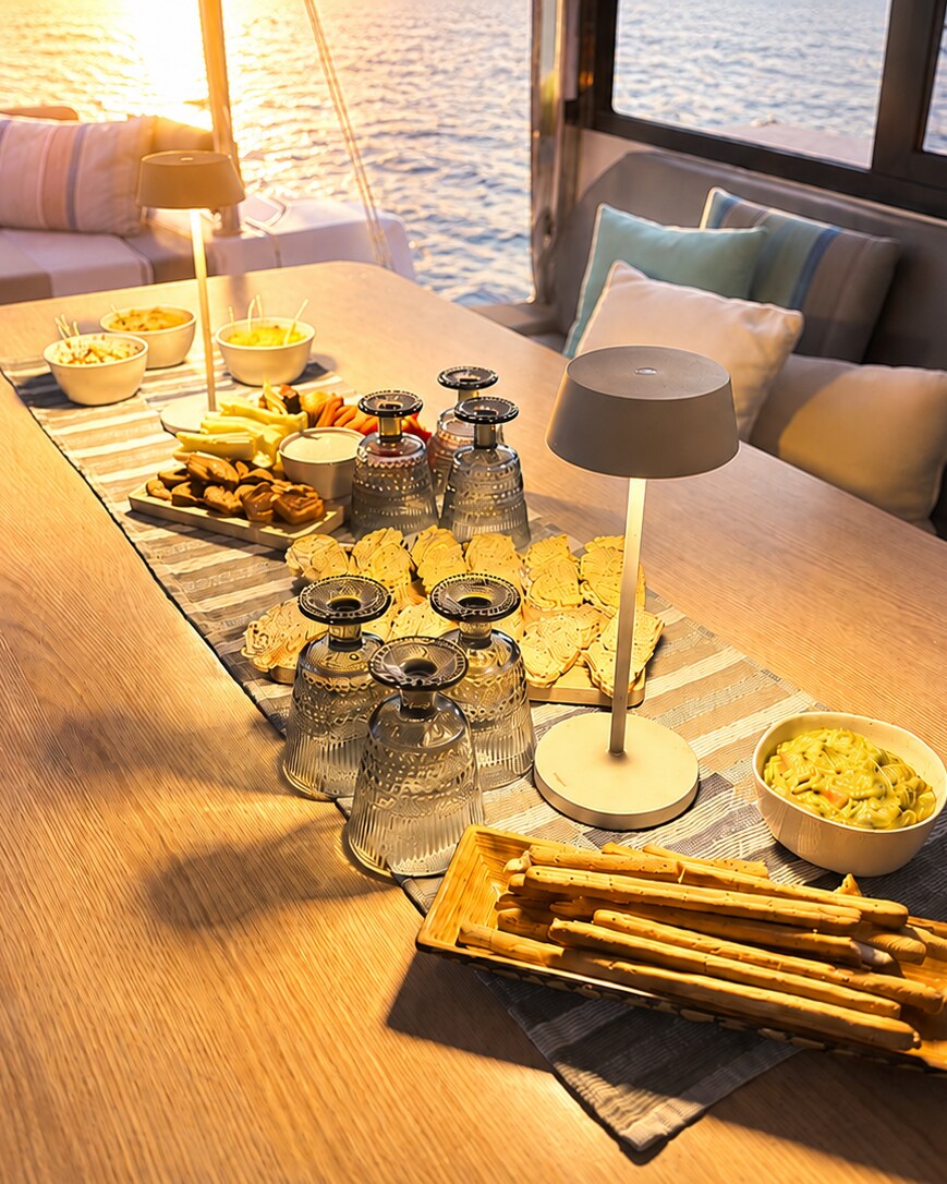 La table dressée pour l'apéritif à bord, face au soleil couchant