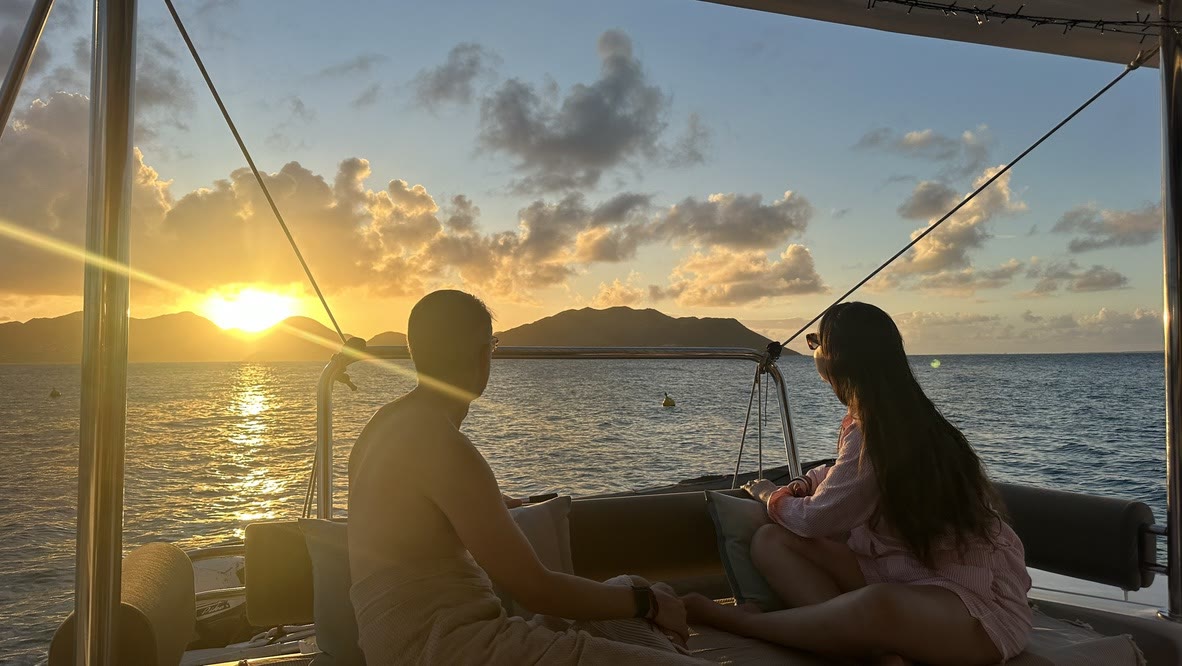 Un couple à bord du catamaran Zéphyr au coucher du soleil à Saint-Martin