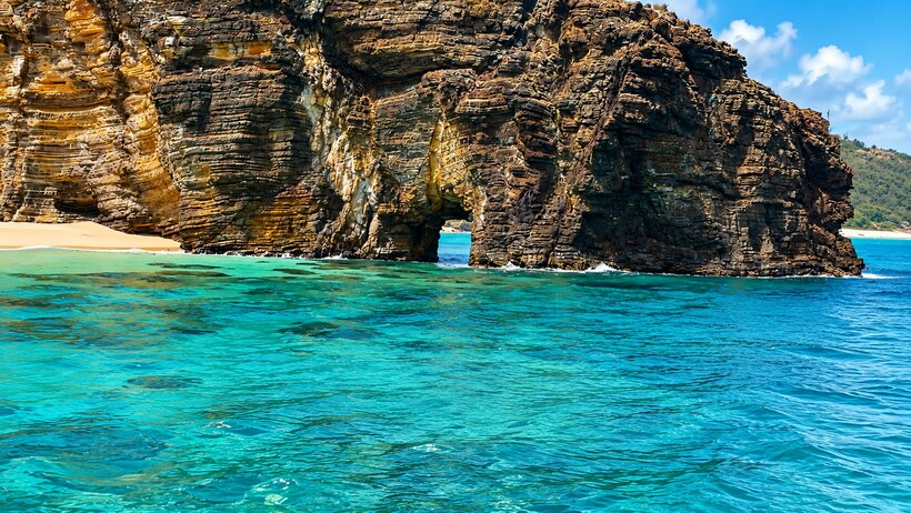 The ochre cliff and arch of Baie Rouge, Saint-Martin